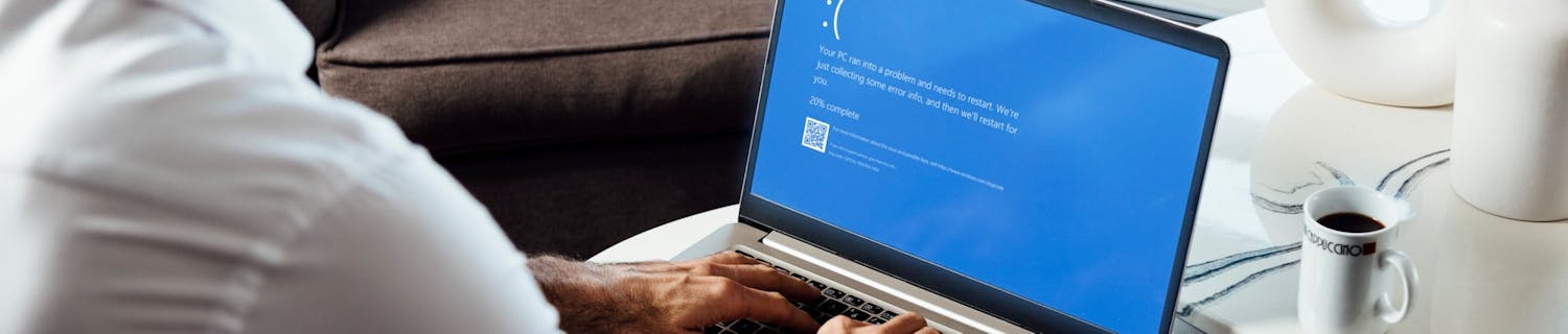 Laptop with BSOD Man sitting with laptop displaying BSOD